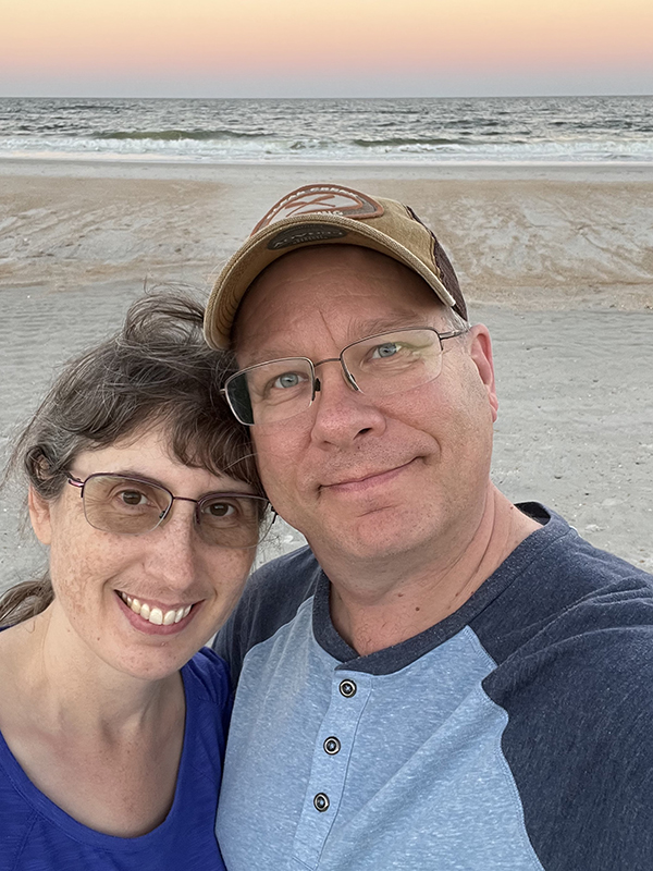 James and Julie on beach with sunset lit sky