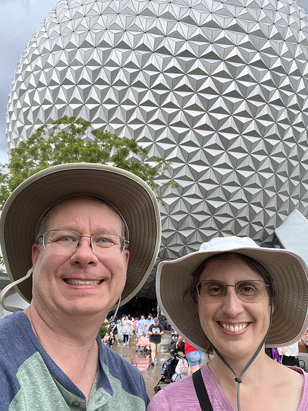 James and Julie with the silver sphere of EPCOT’s Spaceship Earth behind them
